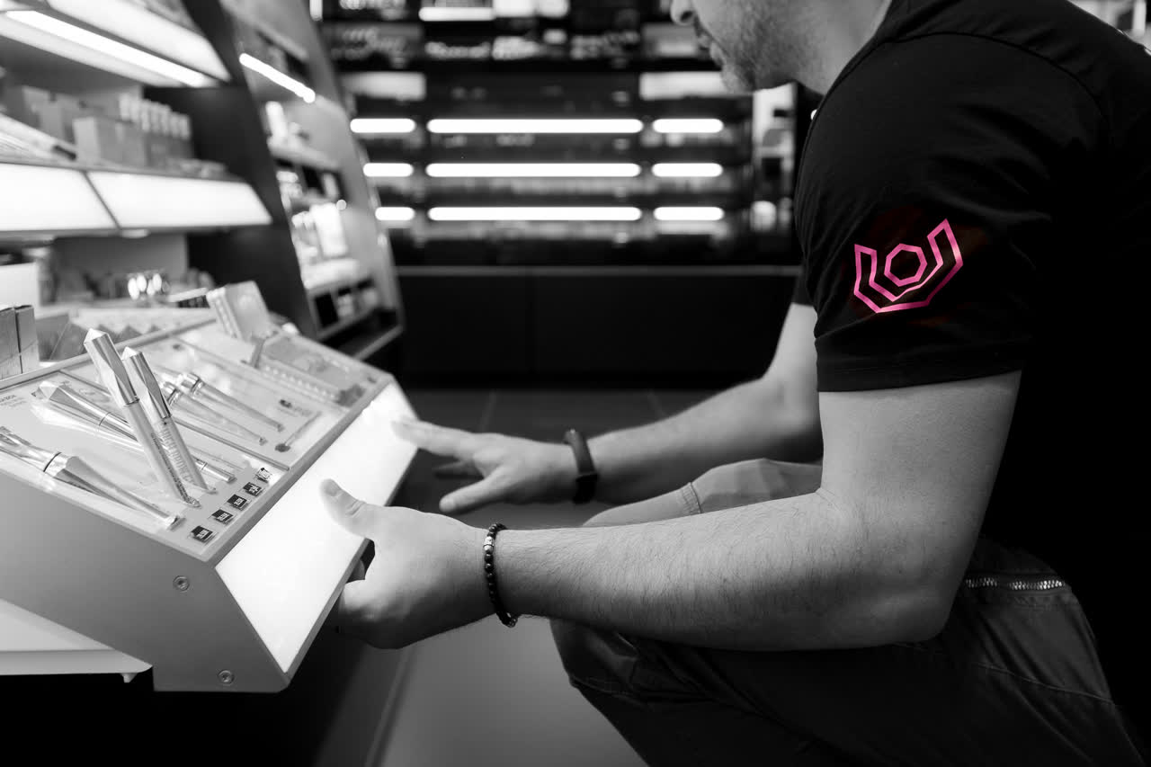A SETUP360 technician adjusting an illuminated cosmetics display